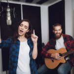 96915374-una-ragazza-e-un-ragazzo-cantano-una-canzone-per-una-chitarra-in-un-moderno-studio-di-registrazione